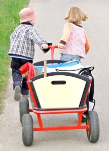 two children pull a loaded wagon together