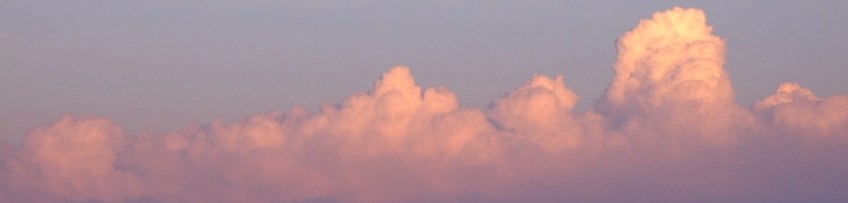 Stacked cumulus clouds tinged with pink