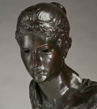 Bronze casting of a pensive young woman in ancient dress with holes for eyes