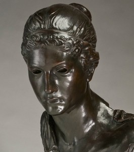 Bronze casting of a pensive young woman in ancient dress with holes for eyes