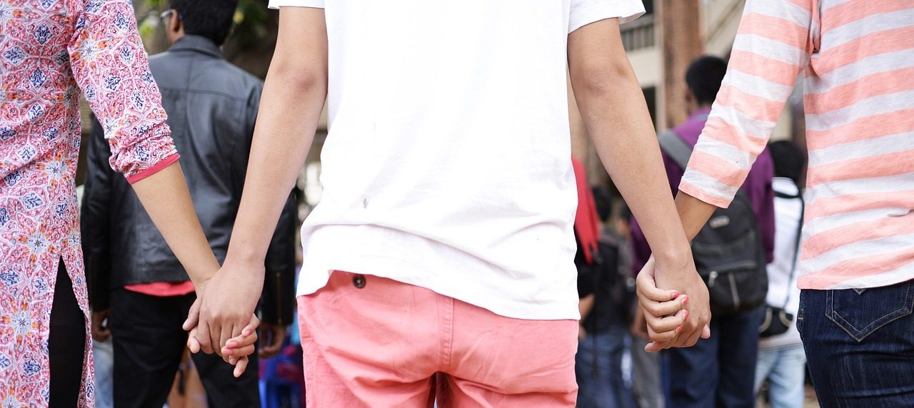 Image by amosii 3 women at a protest viewed from behind, holding hands